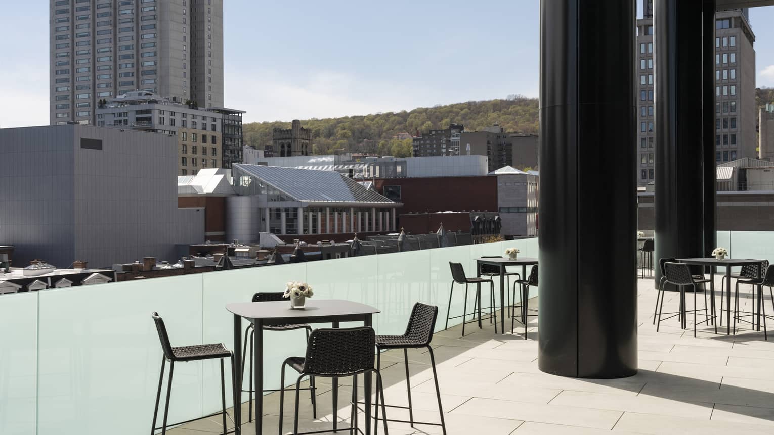 Black tables with flowers and chairs Belvedere Terrace, overlooking city 