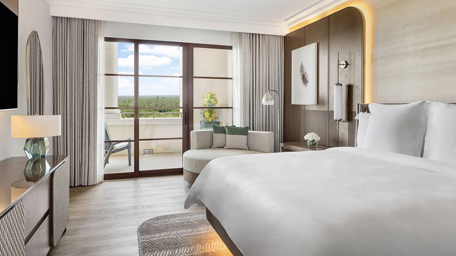 Contemporary hotel room with king bed and walk-out balcony