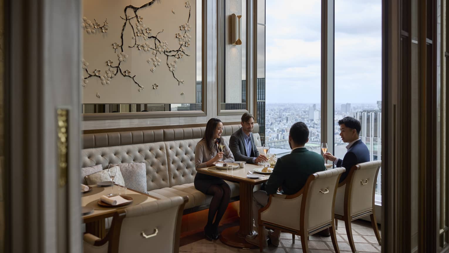 A group dines in a semi-private room at est, a French restaurant in Tokyo, with stunning city views.