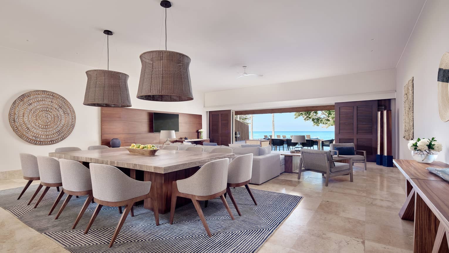 Arena Beach House combined living/dining room with grey area rug, cream and wooden accents