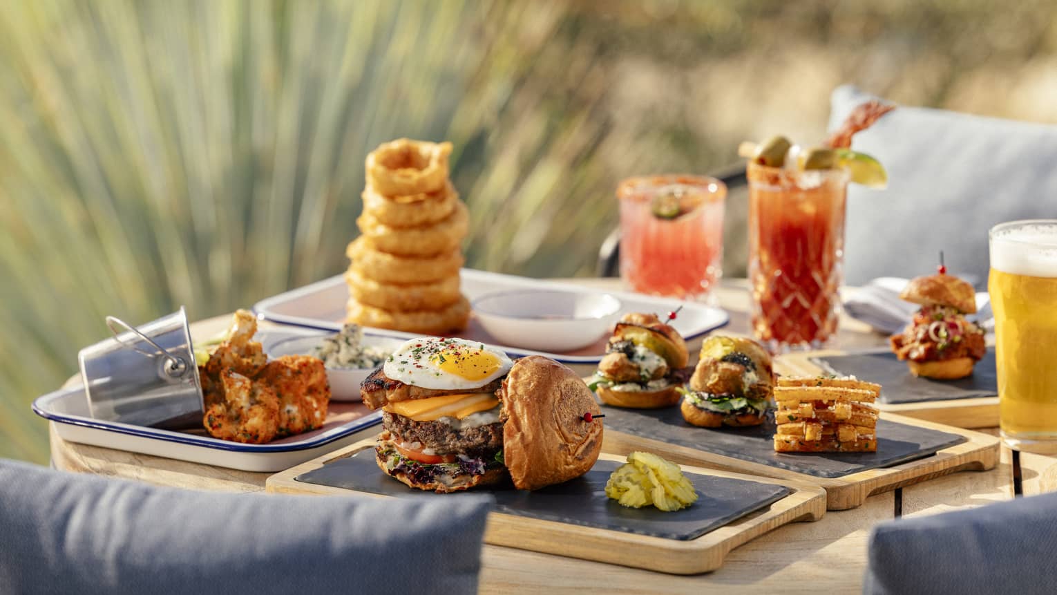 Plates of onion rings and other snacks and various drinks