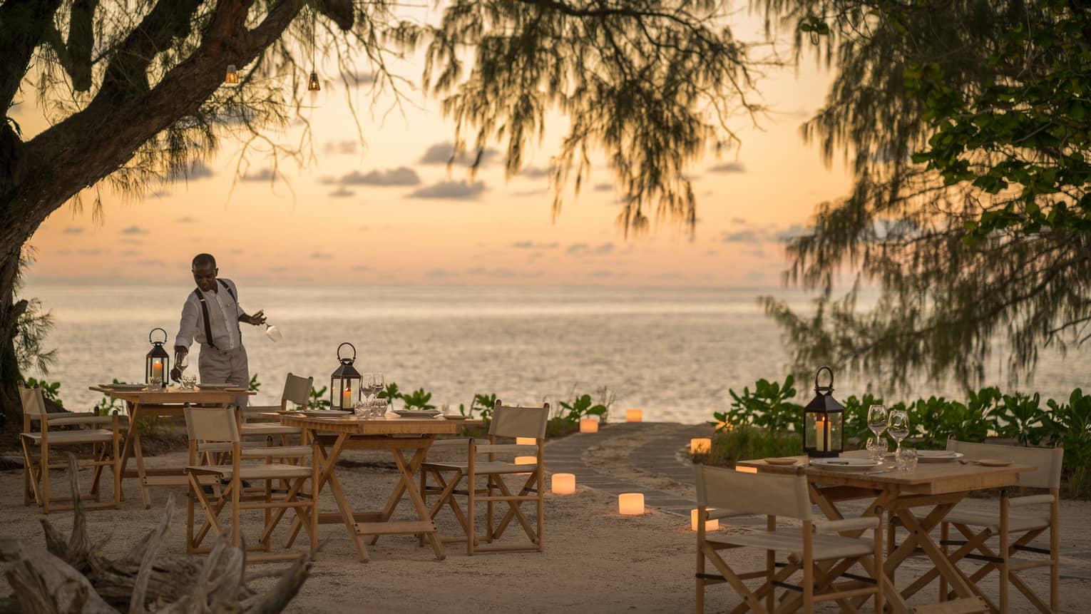 Lighthouse Restaurant on beach decorated with luminaries at sunset