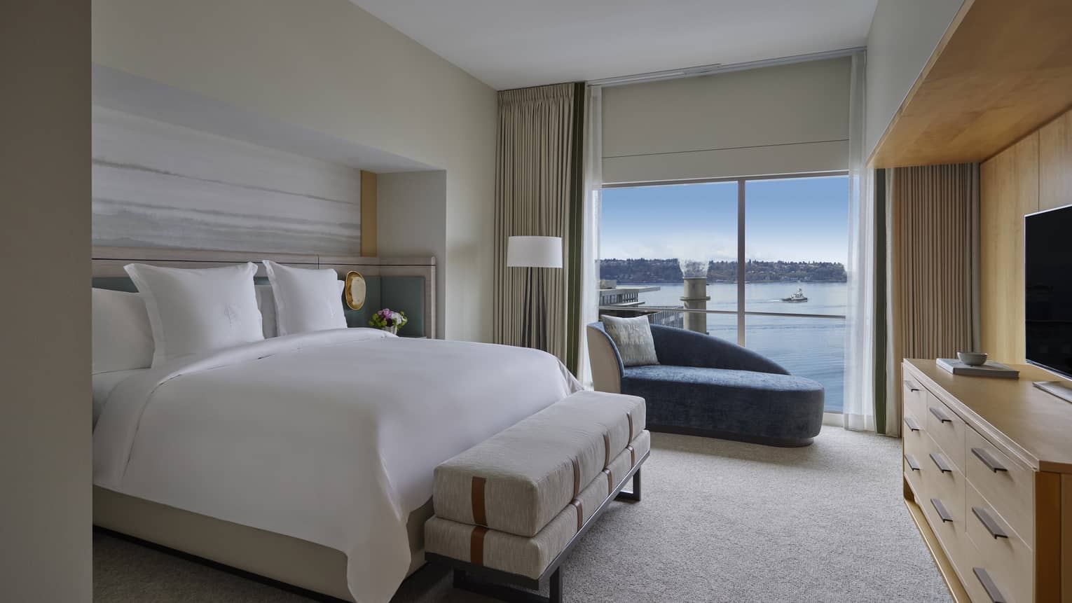 Bedroom with king bed, dresser and TV, and windowside chaise