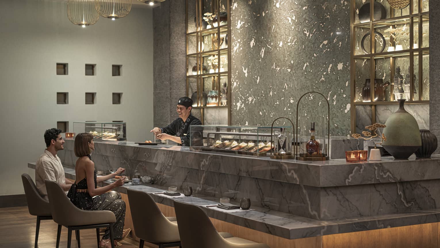 Yatai restaurant modern sushi bar with sushi chef behind and two guests seated