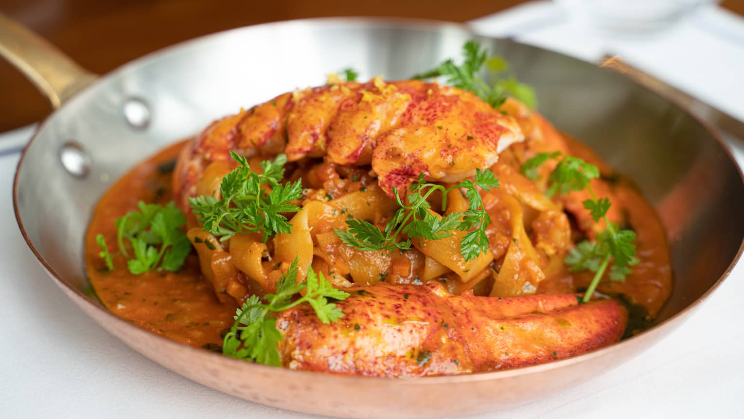 Boccalino signature dish - Chitarra Lobster Pasta in stainless steel pan garnished with fresh parsley