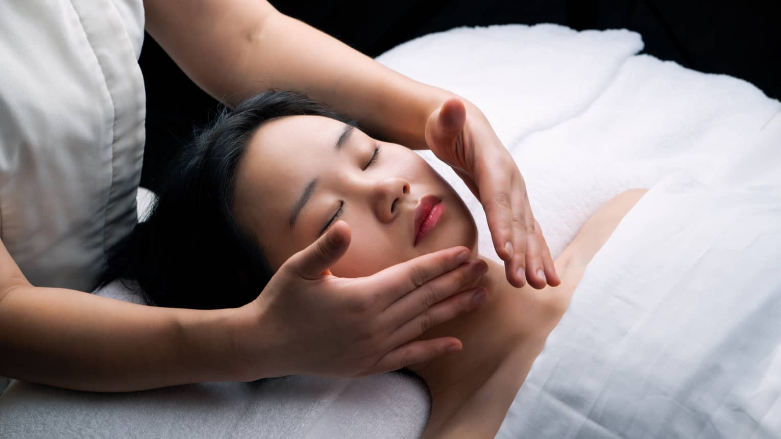 Guest laying on a spa table and getting a facial.