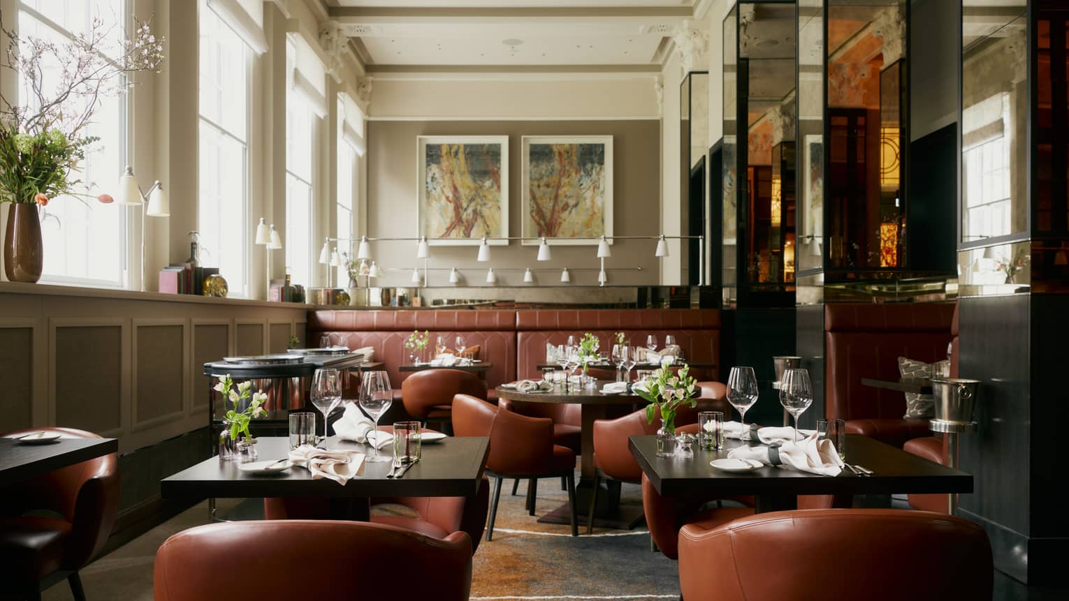 Restaurant featuring square black tables with tan leather chairs
