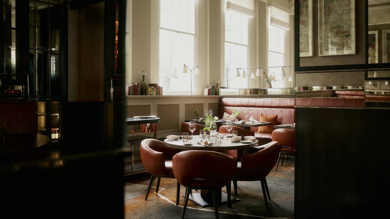 Entrance to an intimate restaurant with leather chairs and sunlight streaming in from windows