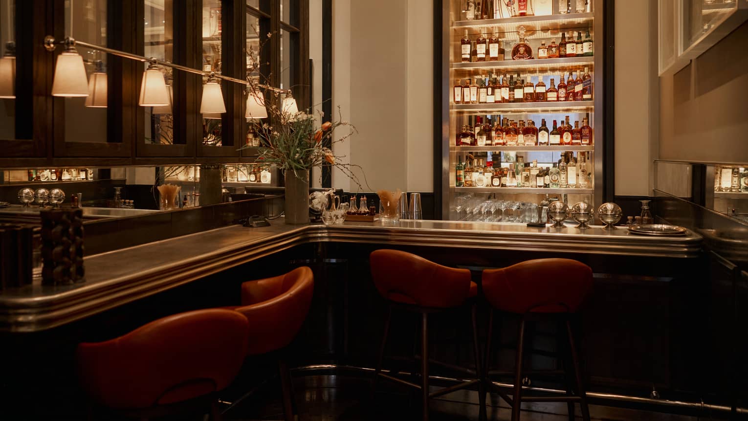 A dimly lit, chic bar with leather seats