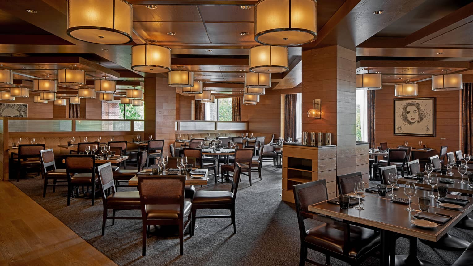 A dimly lit restaurant with large wood tables.