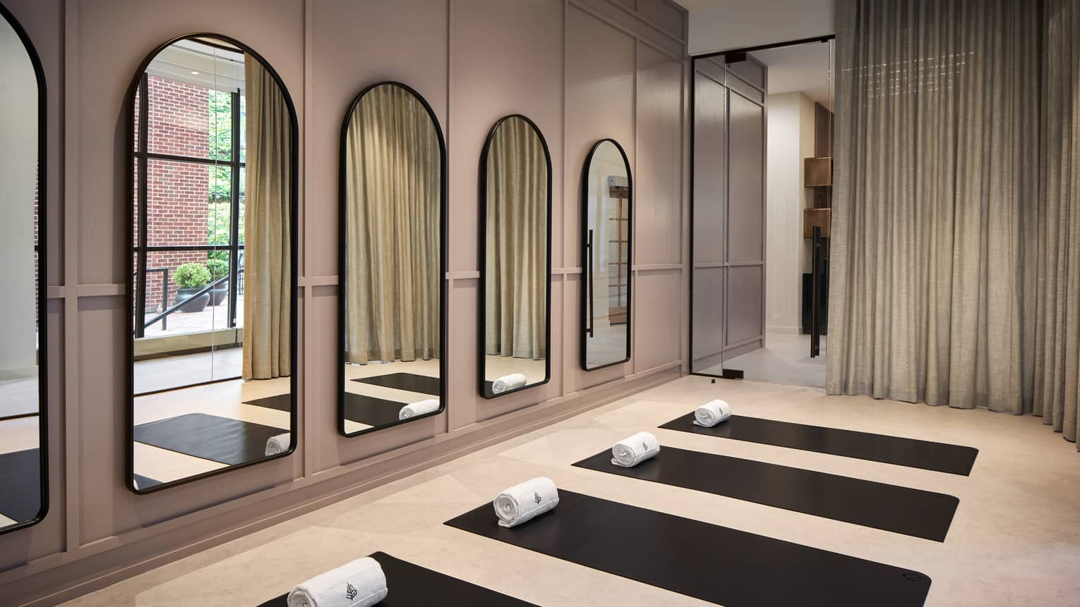 Yoga mats in a yoga studio with mirrors on the wall.