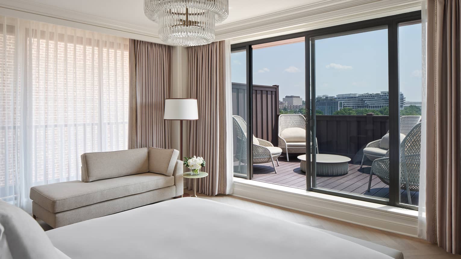 View from the bedroom of a walk-out private terrace with four wing-back chairs, in the Georgetown Suite at Four Seasons Hotel Washington, DC