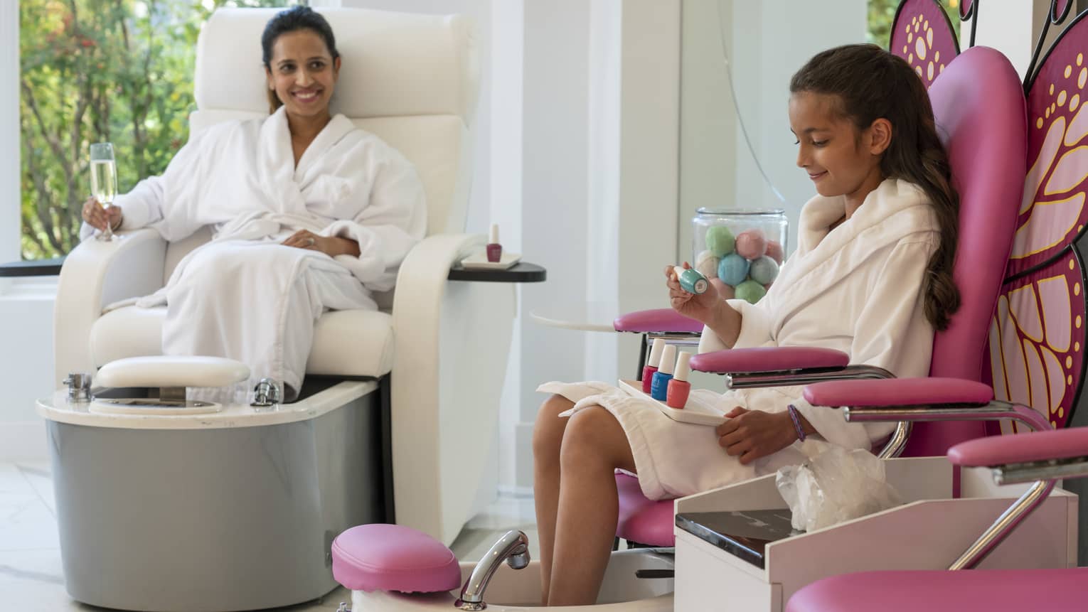 A mother and daughter getting their nails done at a salon.