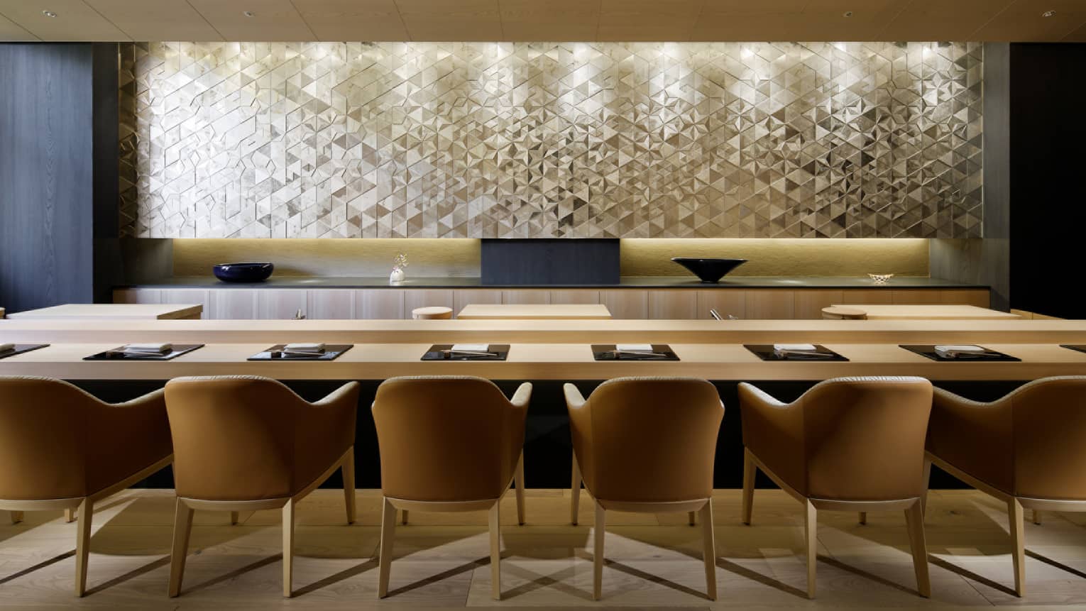 Sushi Wakon large chairs line light wood bar under silver tile wall