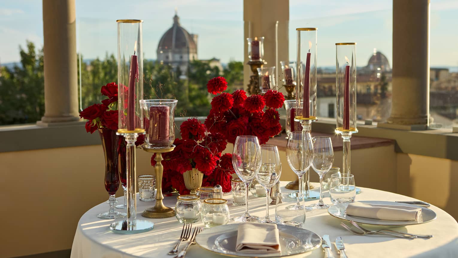 Terrace with elegant, romantic table set for two with crystal glassware and candlesticks looking out to the Duomo
