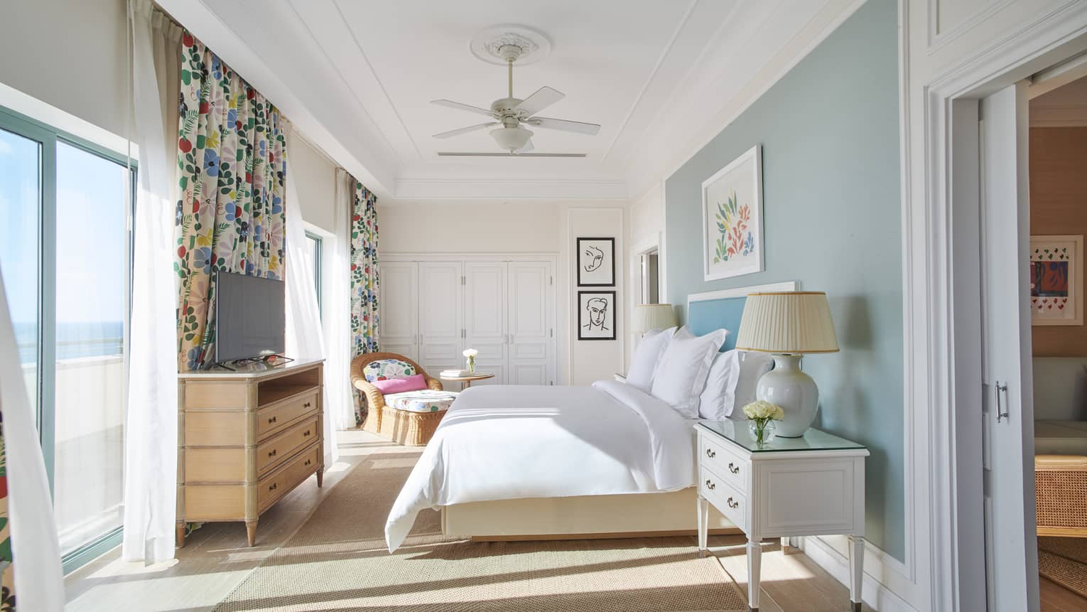 Bedroom with sliding glass doors, turquoise accent wall, king bed