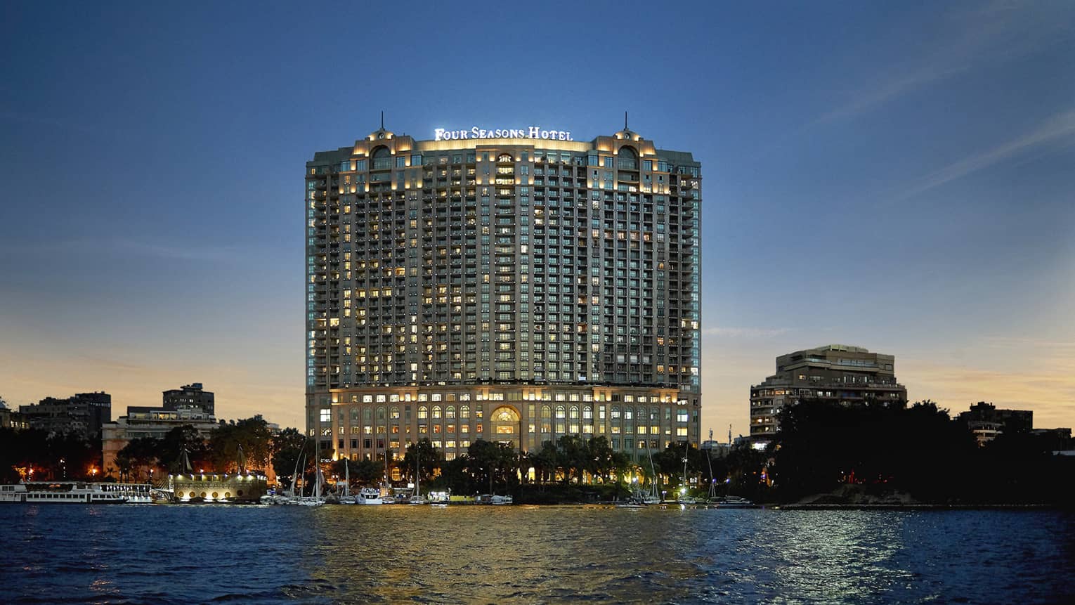 Hotel exterior illuminated at dusk, along the Nile River