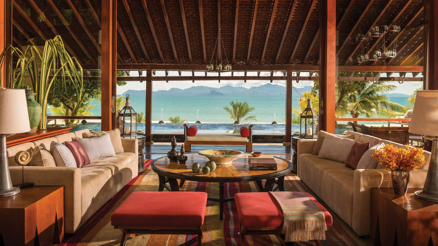 The imperial villa’s outdoor terrace with Malay décor and furniture, overlooking the ocean and mountains. 