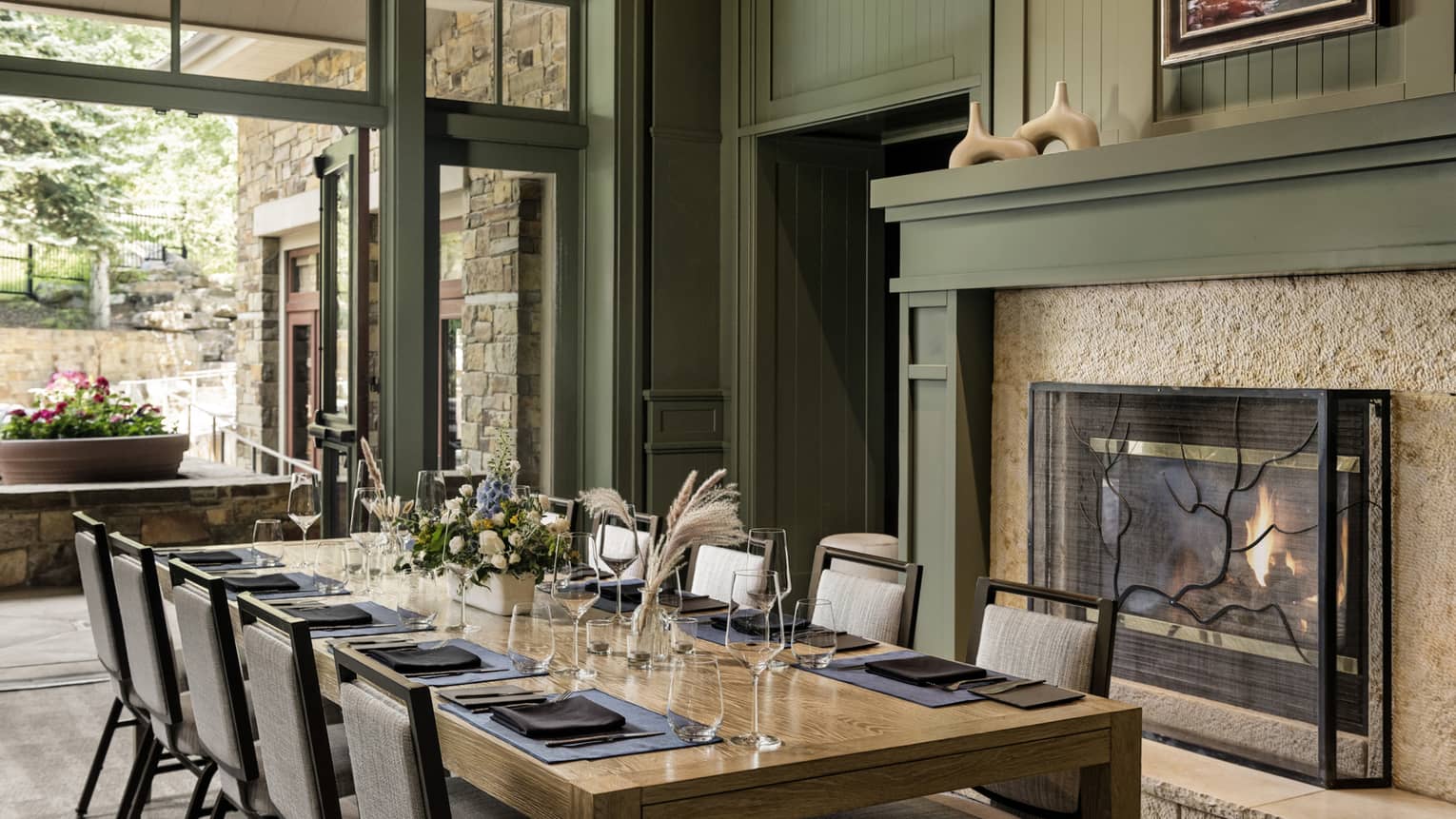 Private dining room with table set for 10 next to a fireplace and outdoor terrace access
