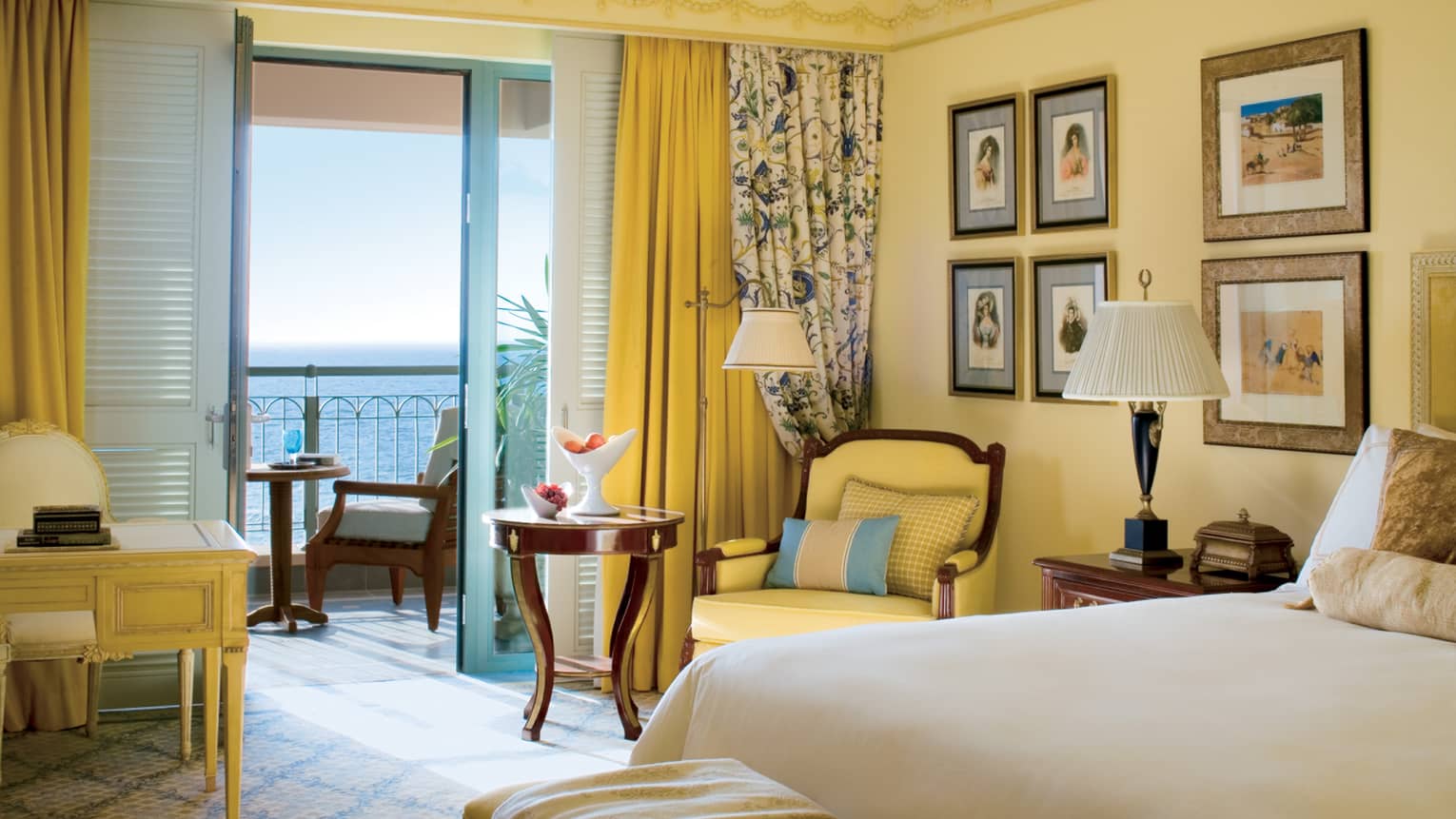 Sea-View Room with warm yellow walls, decor and floral accents, open patio door with Mediterranean Sea view