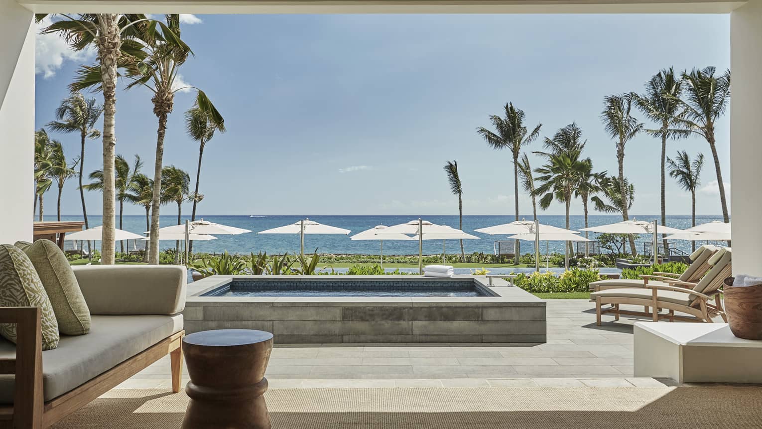 Pacific Suite open to wall to patio with stone plunge pool, lounge chairs, ocean views