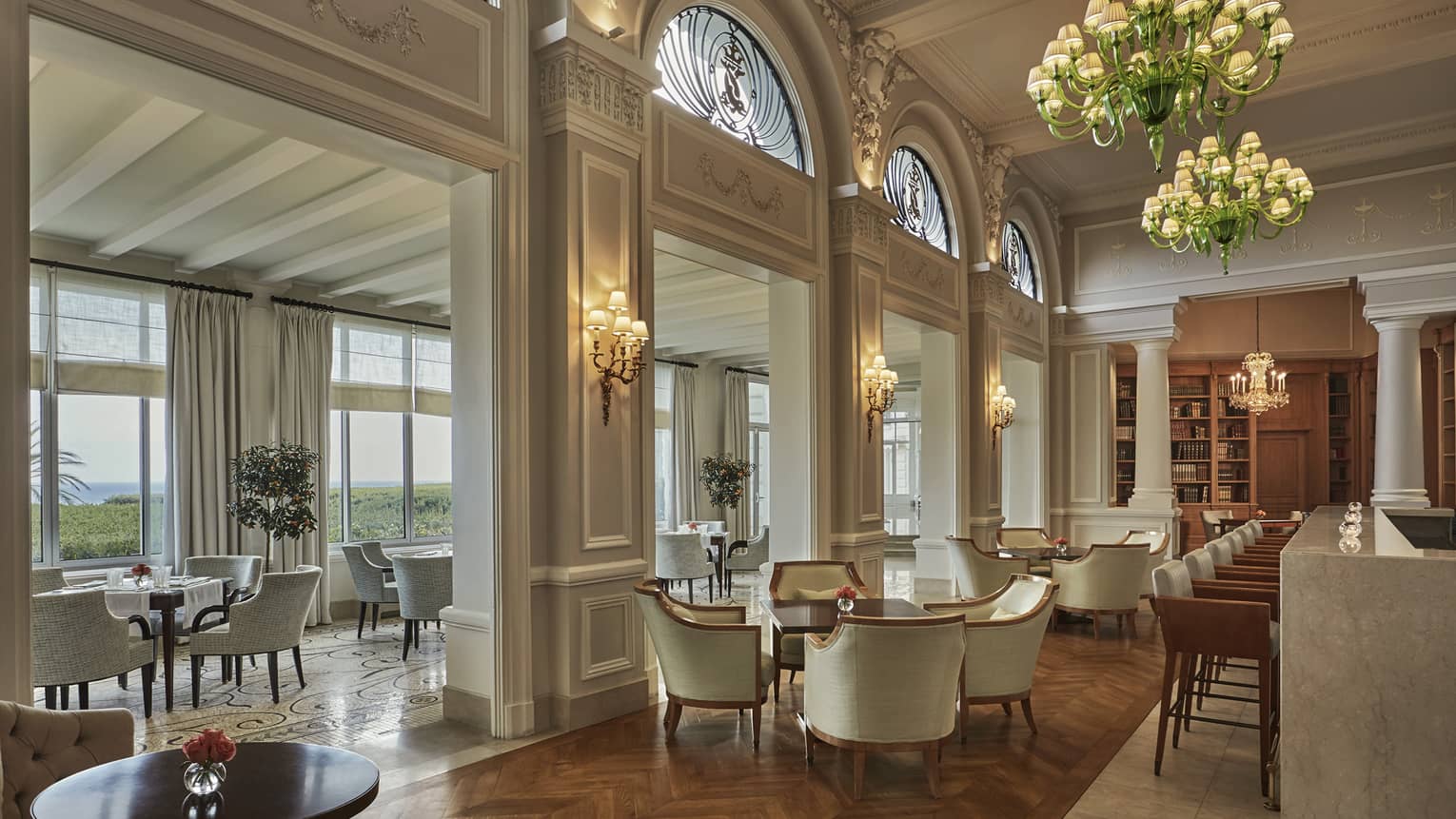 Le Bar lounge tables, chairs under murano chandeliers