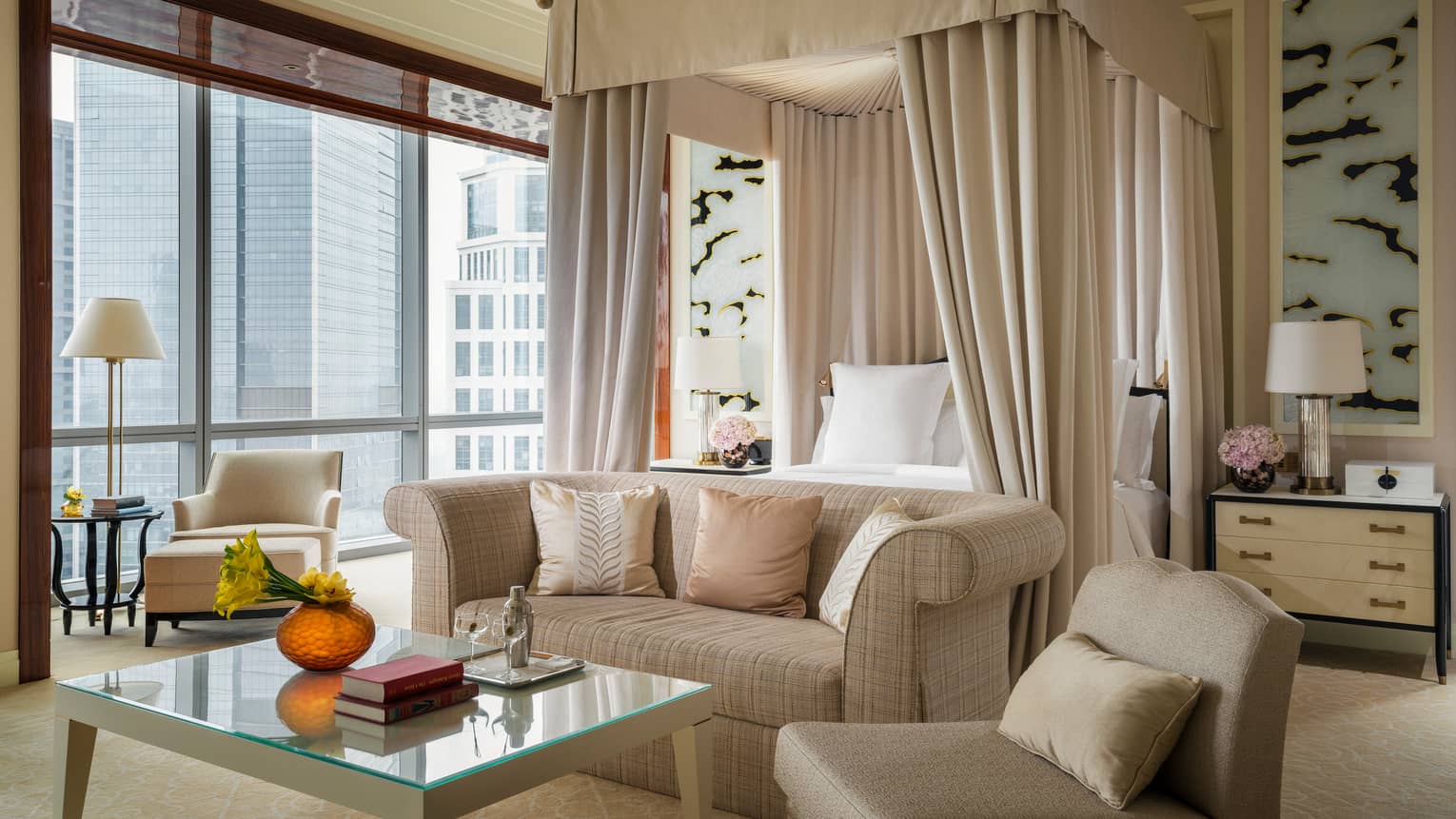 Presidential Suite seating area in front of poster bed with ivory fabric canopy, large window