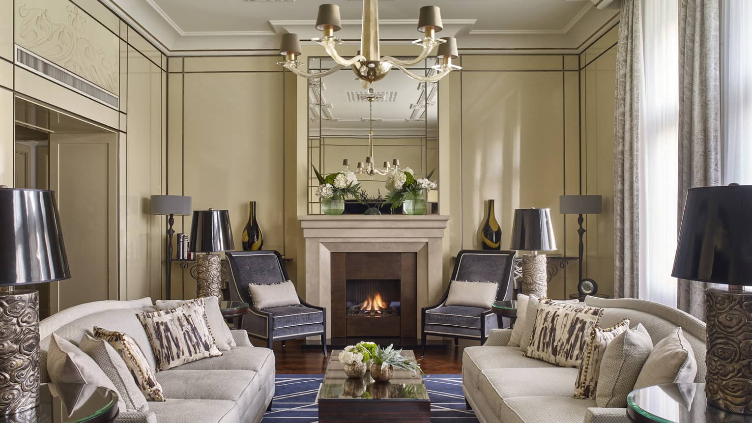 Grand sitting room in Royal Suite with fireplace, two couches, rug, lamps, drapes