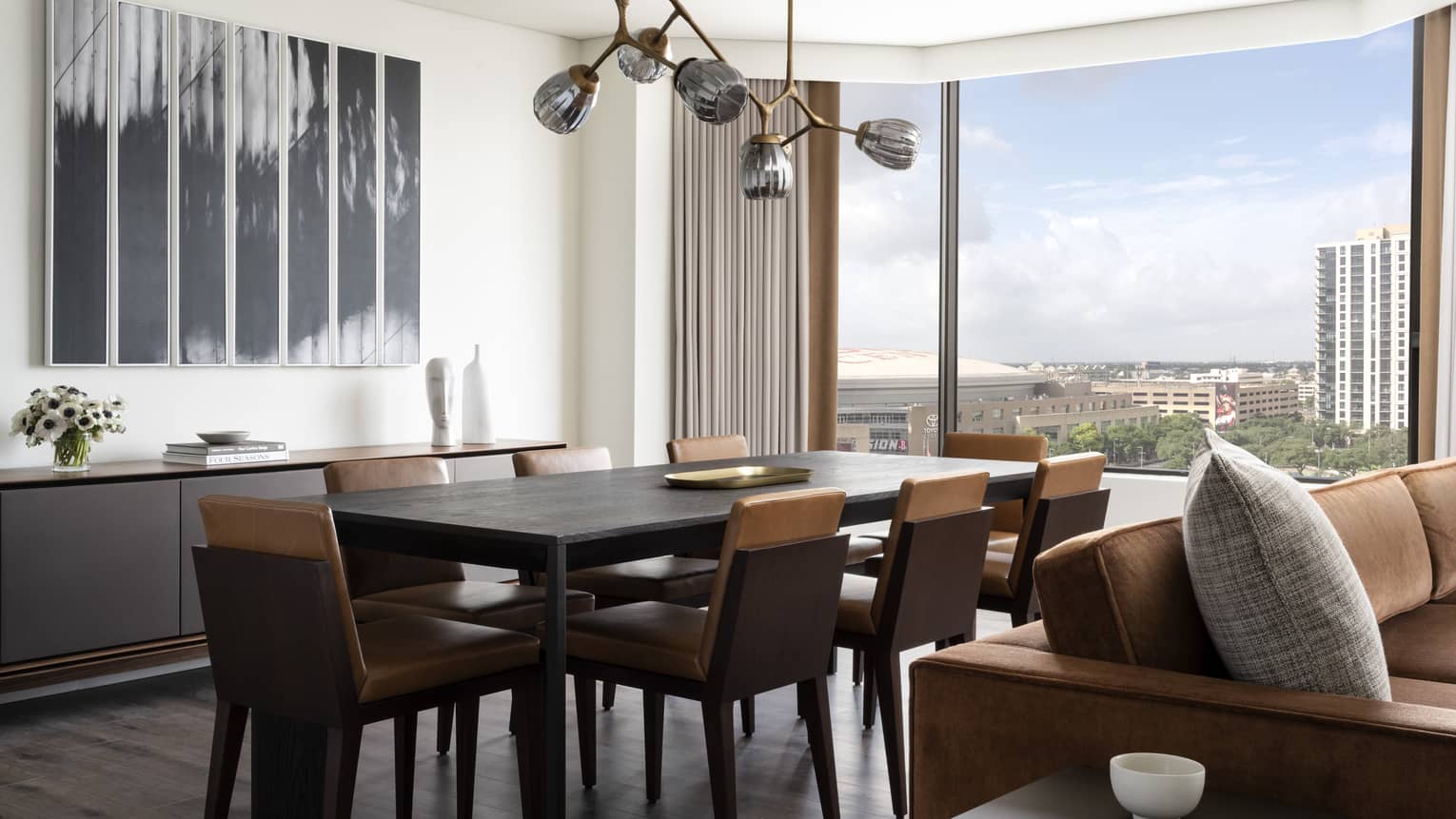 Dining room with table and eight chairs, modern hanging lamp, large window with city view