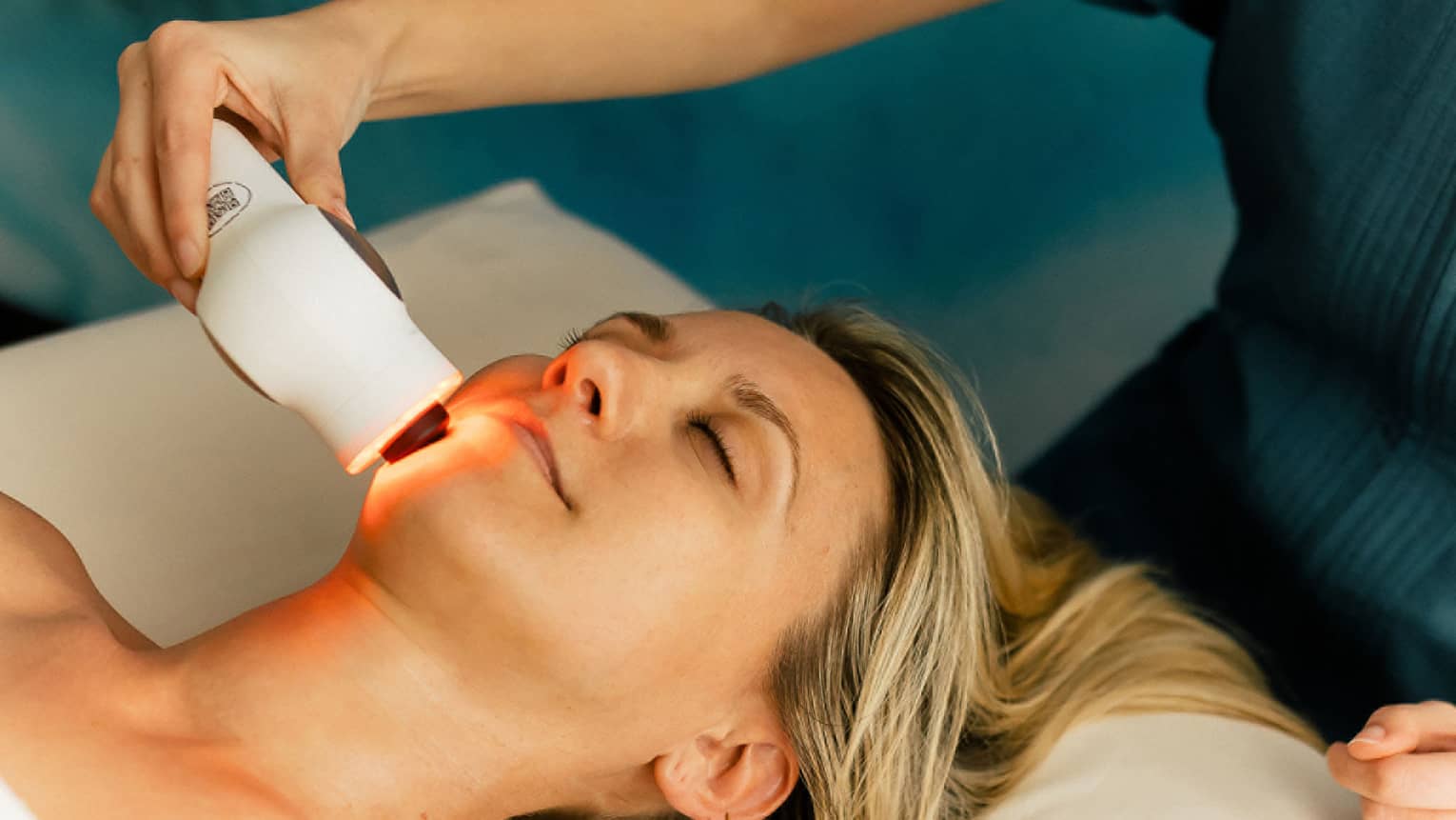 Woman gets a laser treatment on her face at a spa