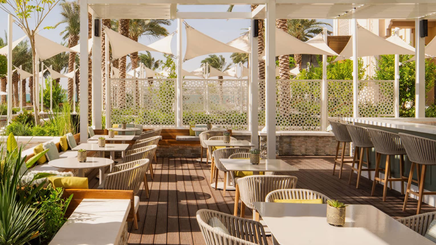 Outdoor restaurant terrace set underneath white pergola