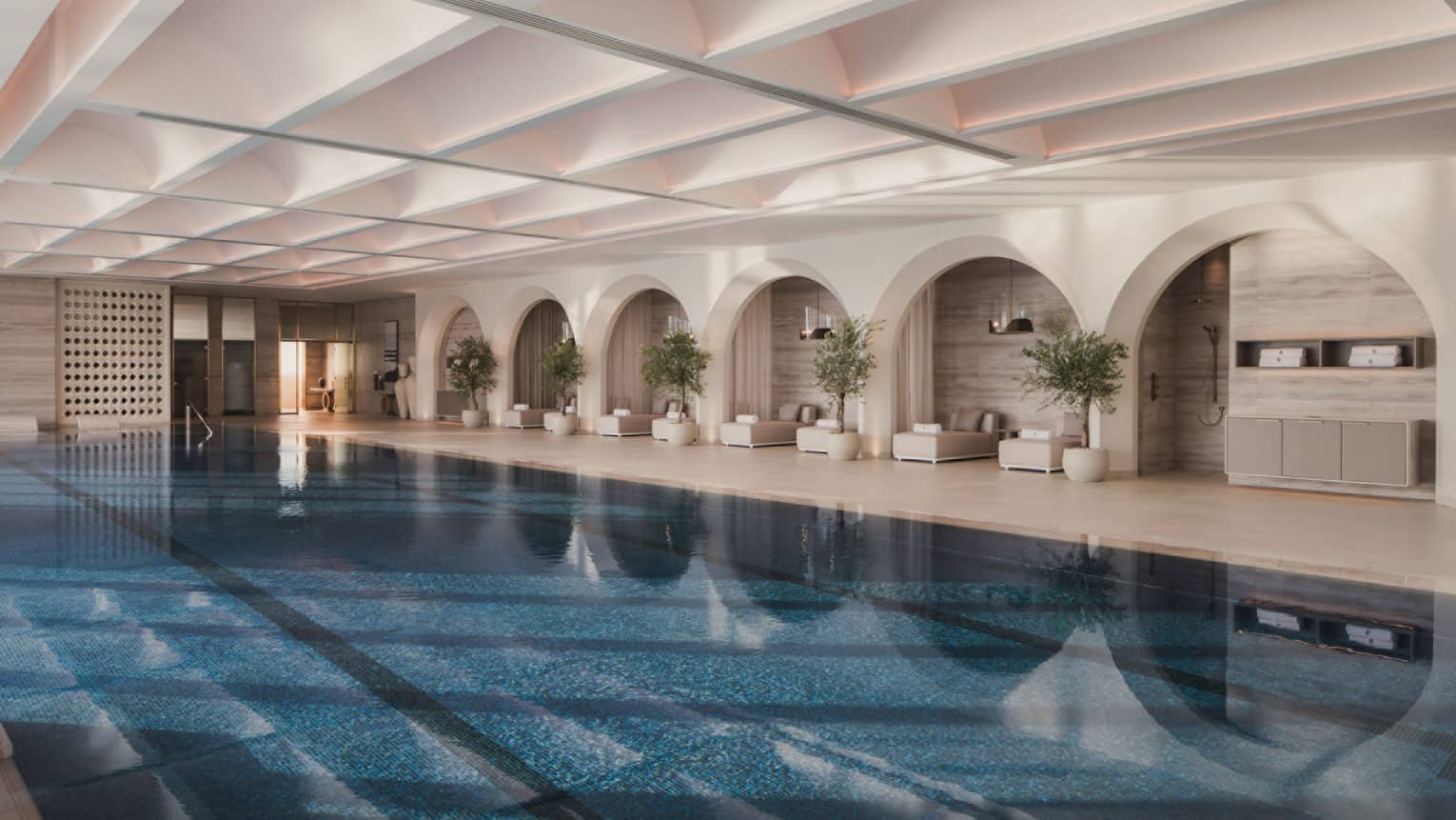 Large indoor swimming pool with pool lounge chairs