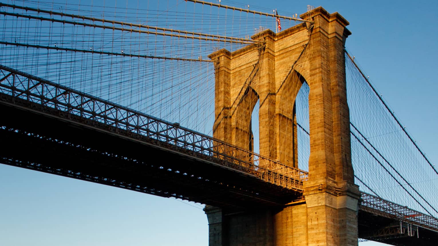 The Brooklyn Bridge at sunset on the water 