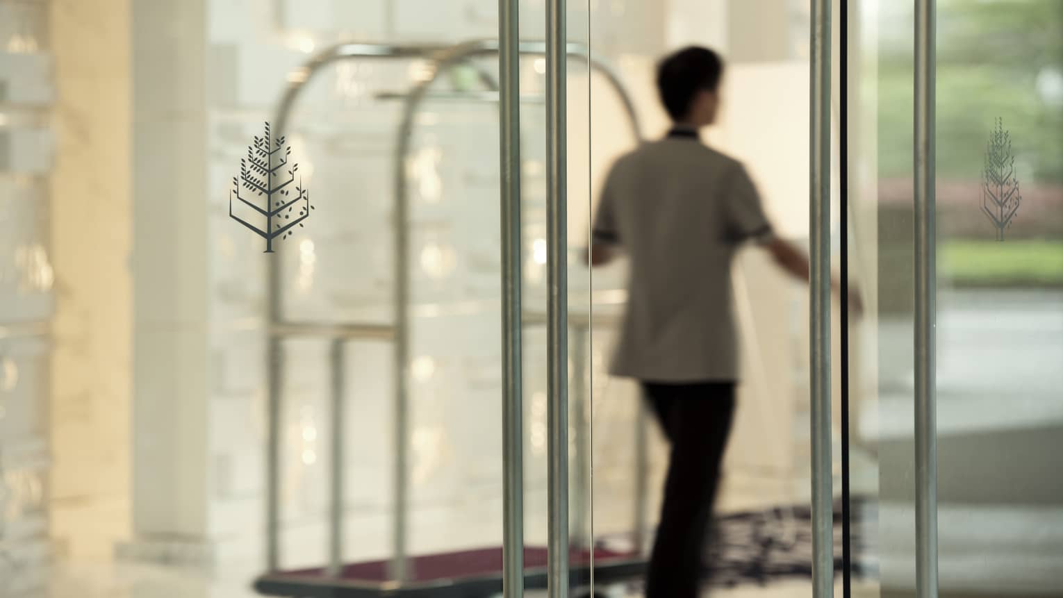 Bellman drives luggage cart through main Hotel doors