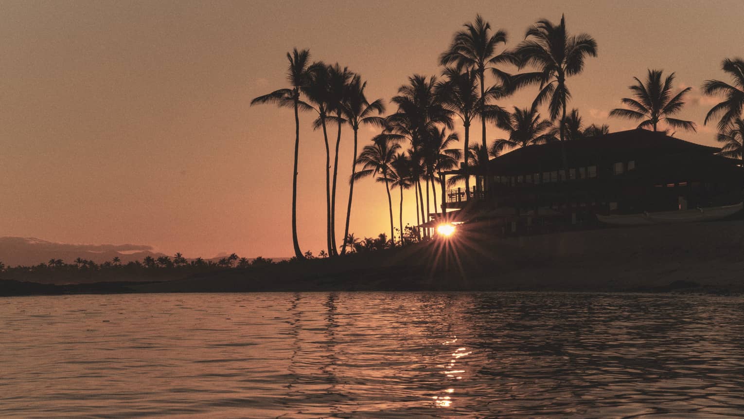Tropical resort on the water at sunset