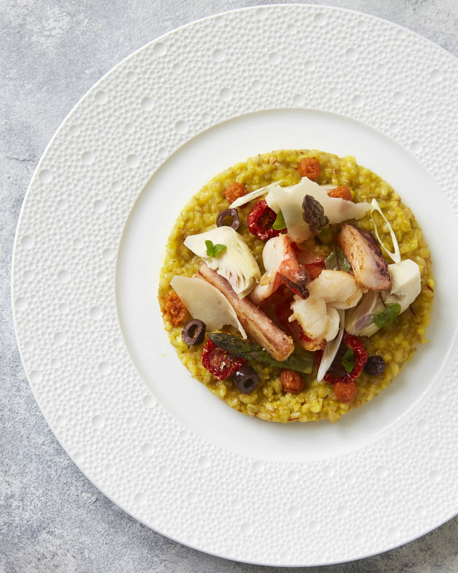 A seafood risotto dish served on a white plate