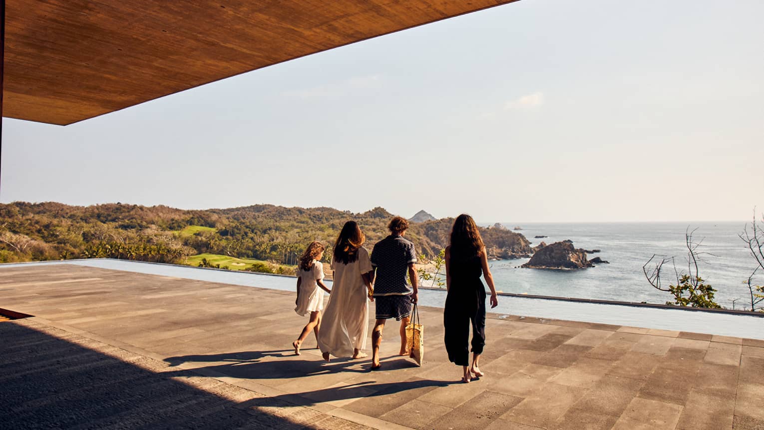 People walking onto the outdoor terrace overlooking the sea