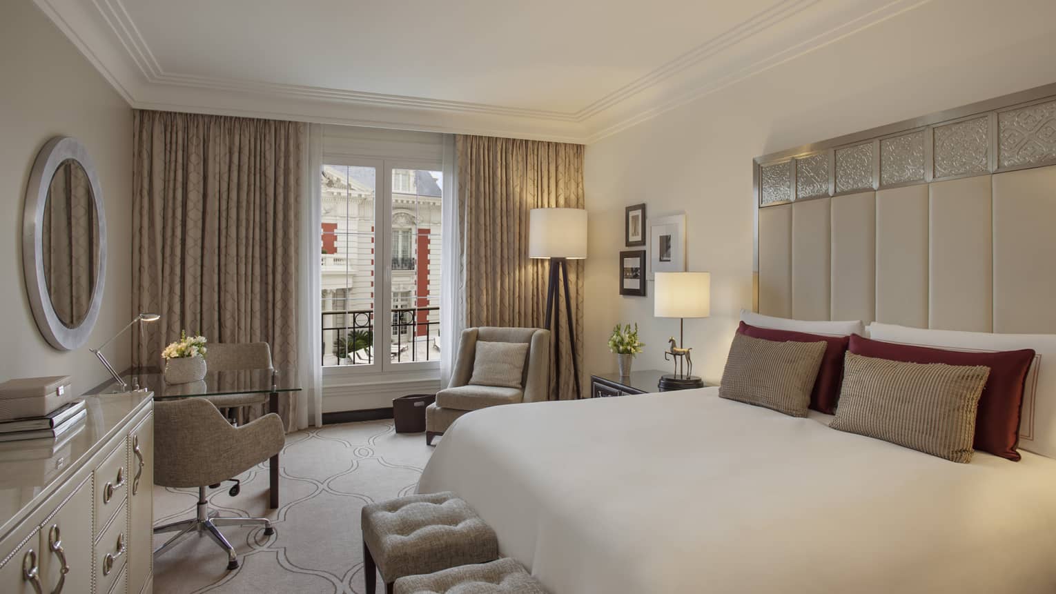 Mansion-View Room with clean, white-and-cream decor, tall padded headboard with silver details, white plush benches, chairs