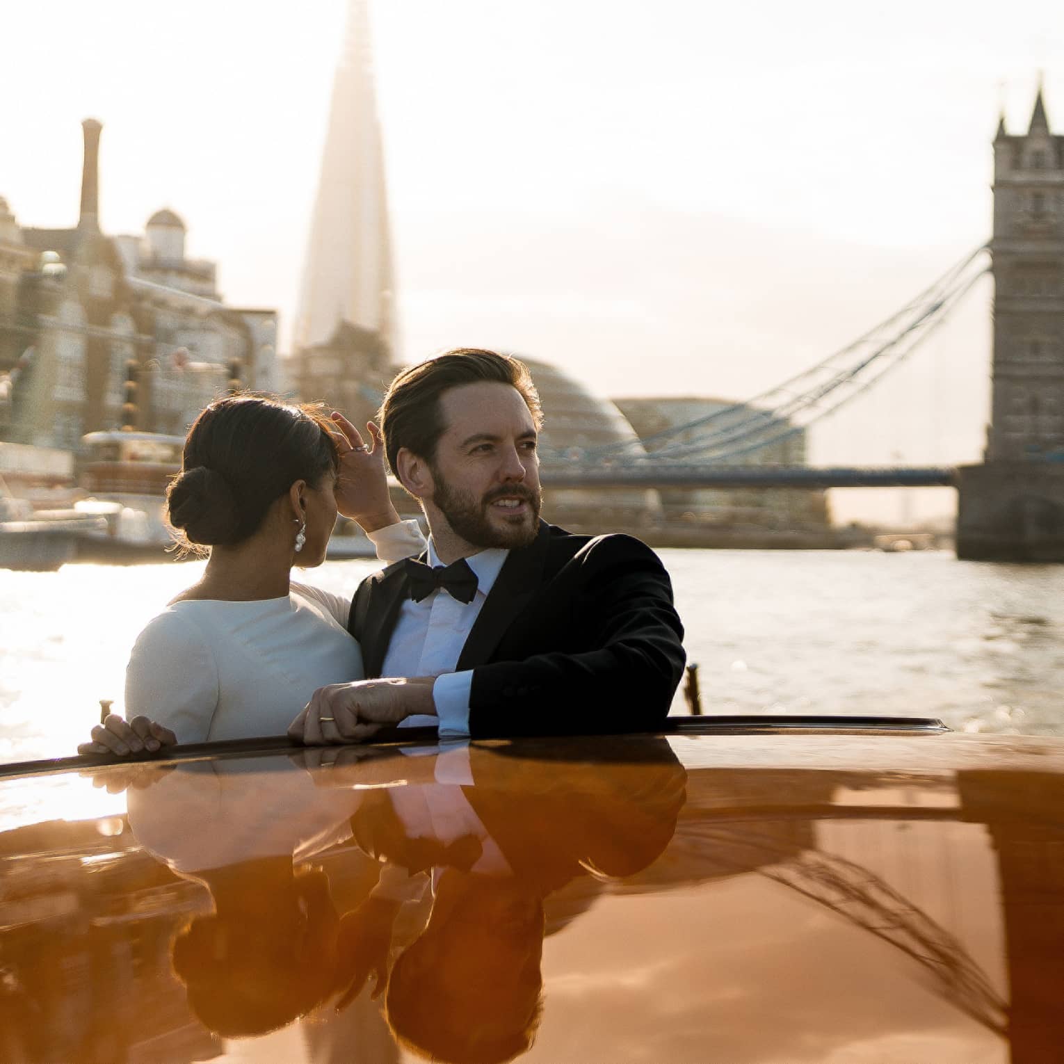 A couple enjoy on a romantic river cruise, surrounded by iconic city landmarks.
