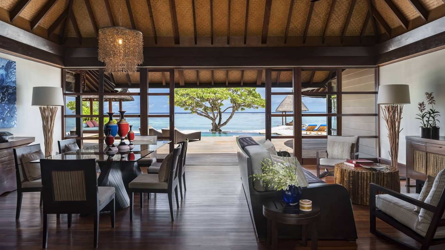 Wood-floored living room, opening up to the beach, of a Two-Bedroom Royal Beach Villa