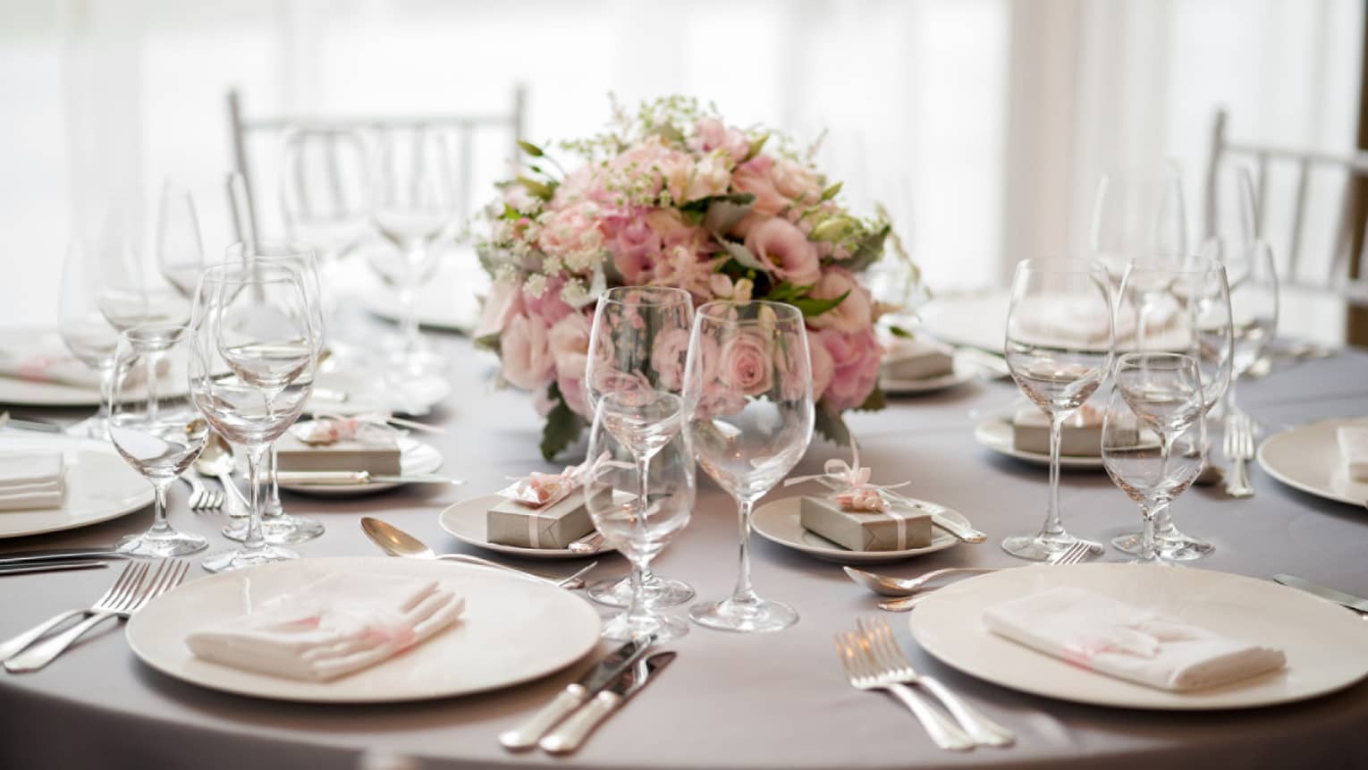 Wedding reception table setting with pink rose floral centrepiece