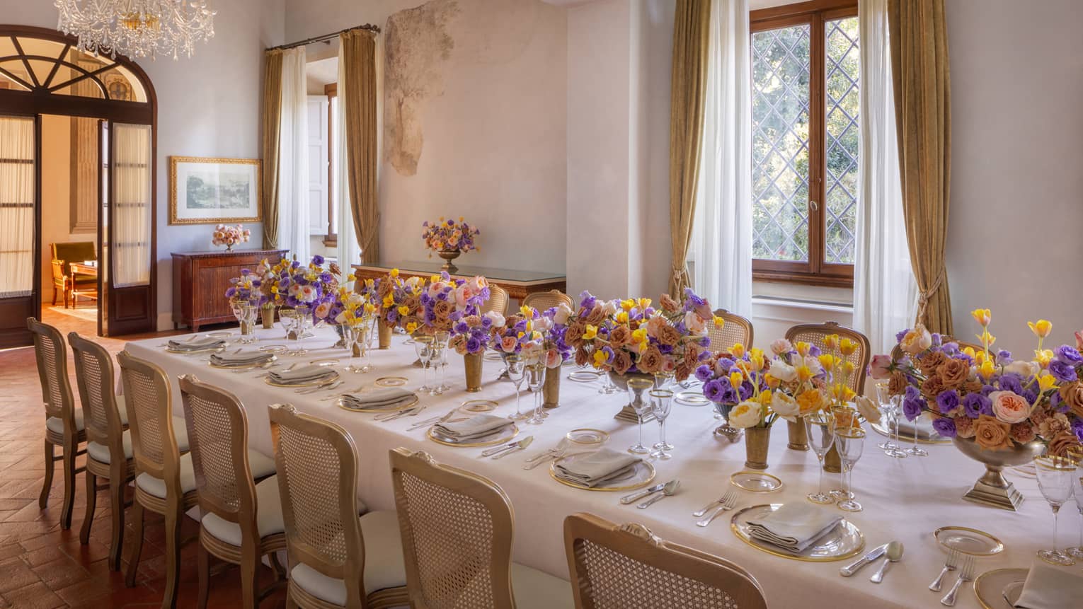 Meeting room with elegantly set long table with colourful flower centrepieces down the middle