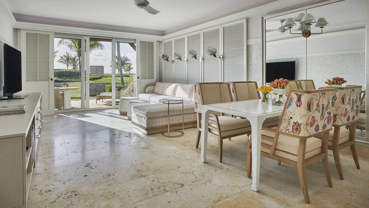 Spacious suite with marble floors, modern beach decor, glass patio doors to garden