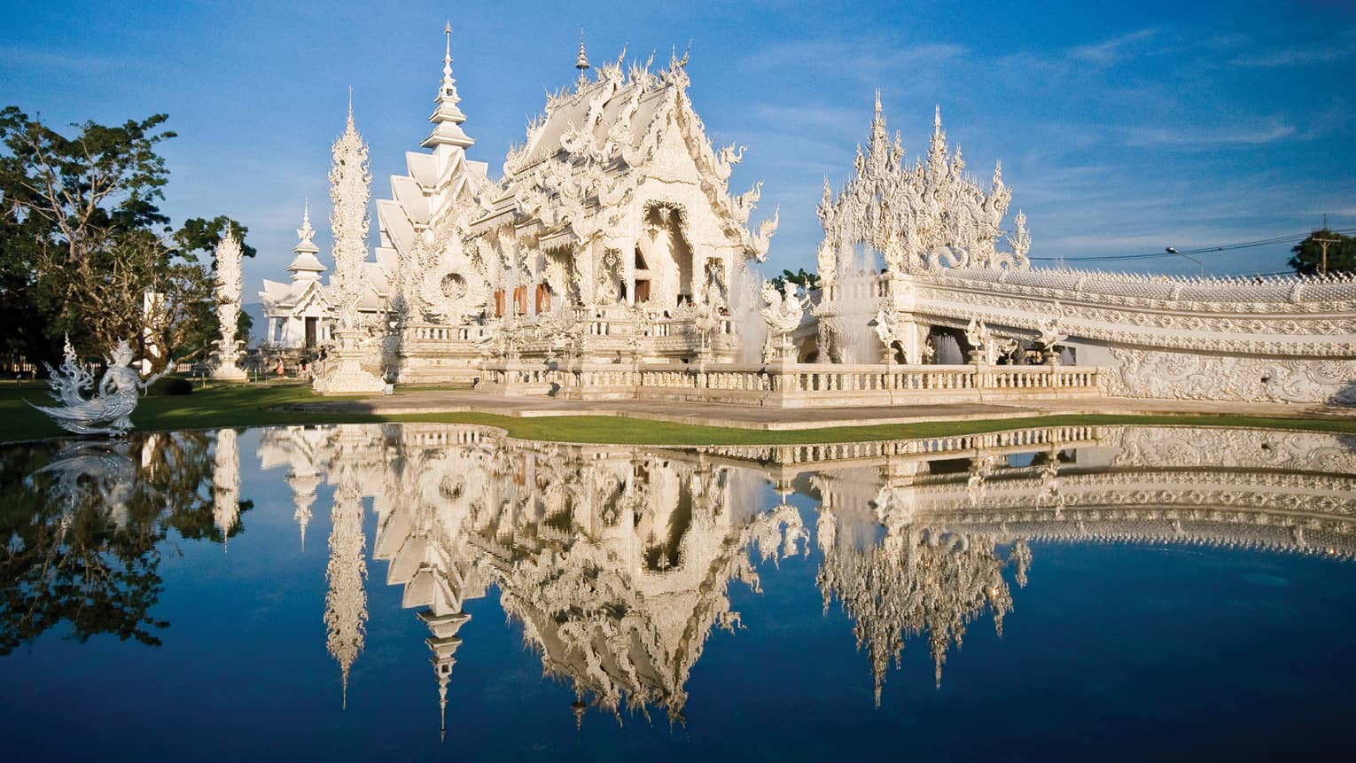 An ornate white castle reflecting in a pond