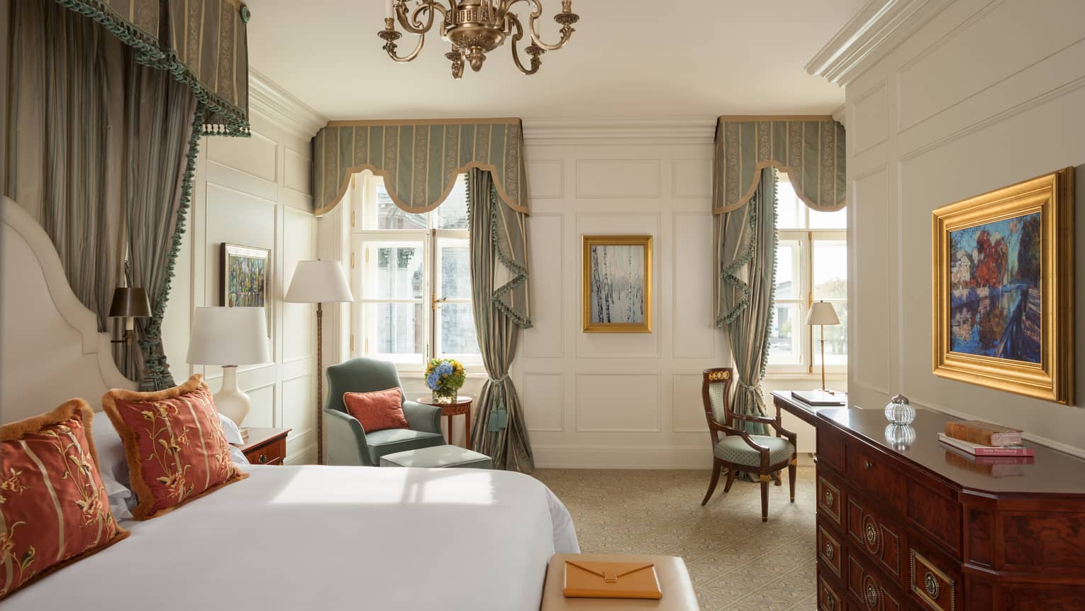 Palace Suite bed with elegant canopy, bench with clutch purse, dressers, chairs under chandelier