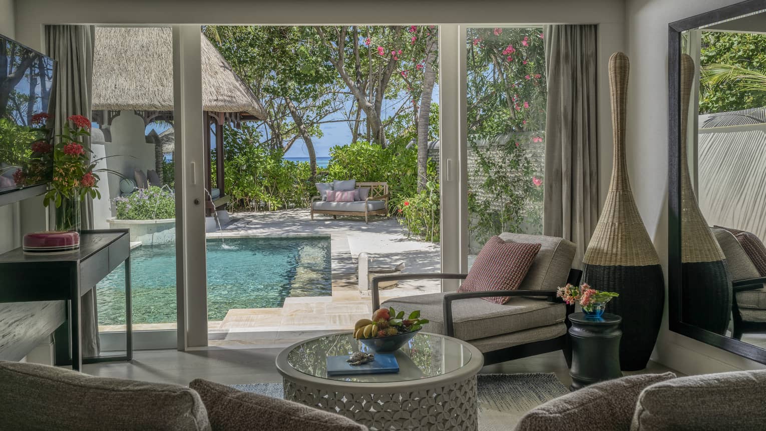 Living room opening to pool deck, with beach in the distance