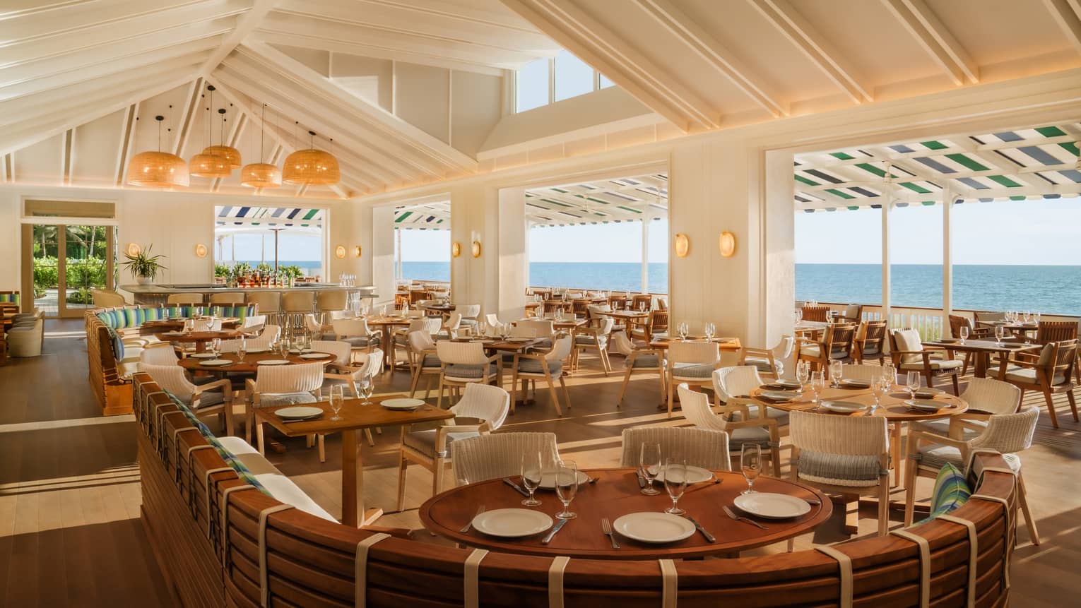 Brighty lit dining room with indoor and outdoor seating and an ocean view