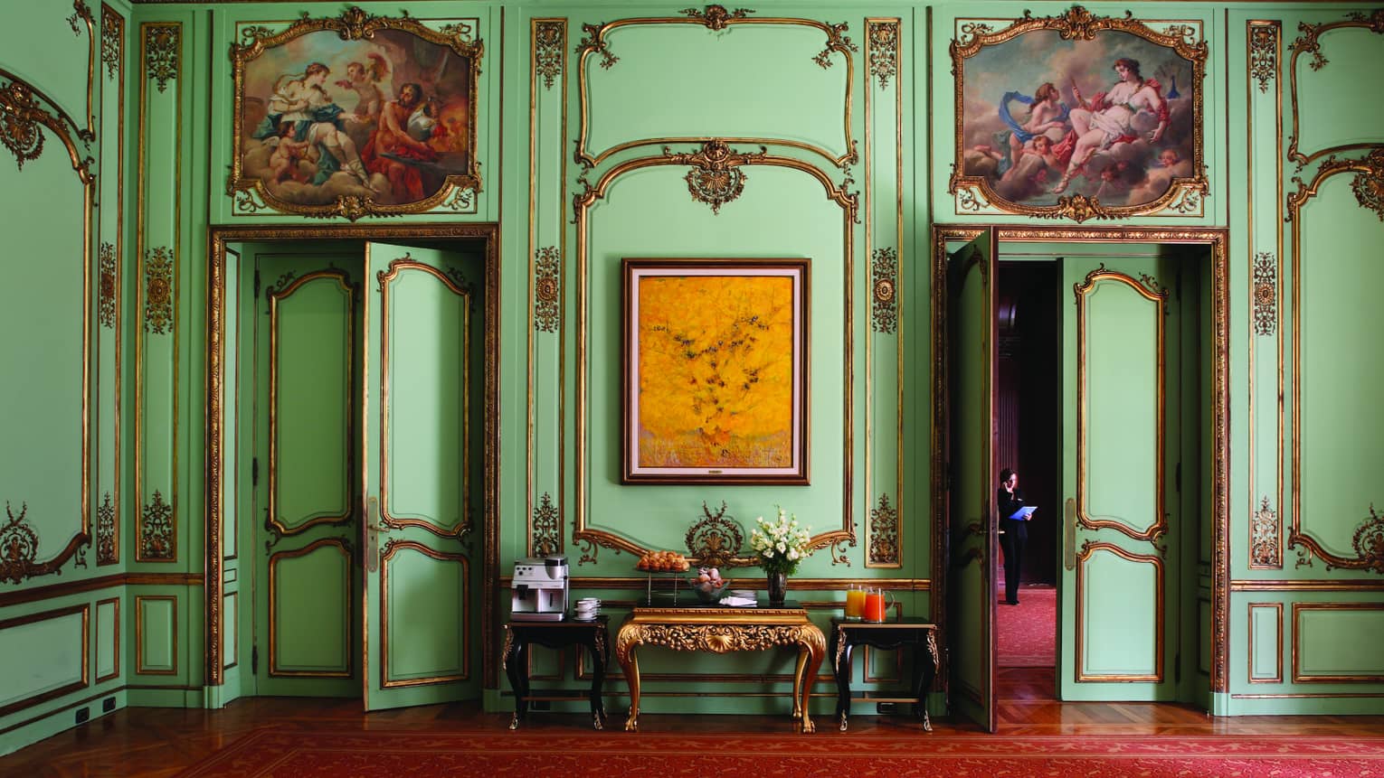 Antique green wall with gold moulding accent trim, gold console table
