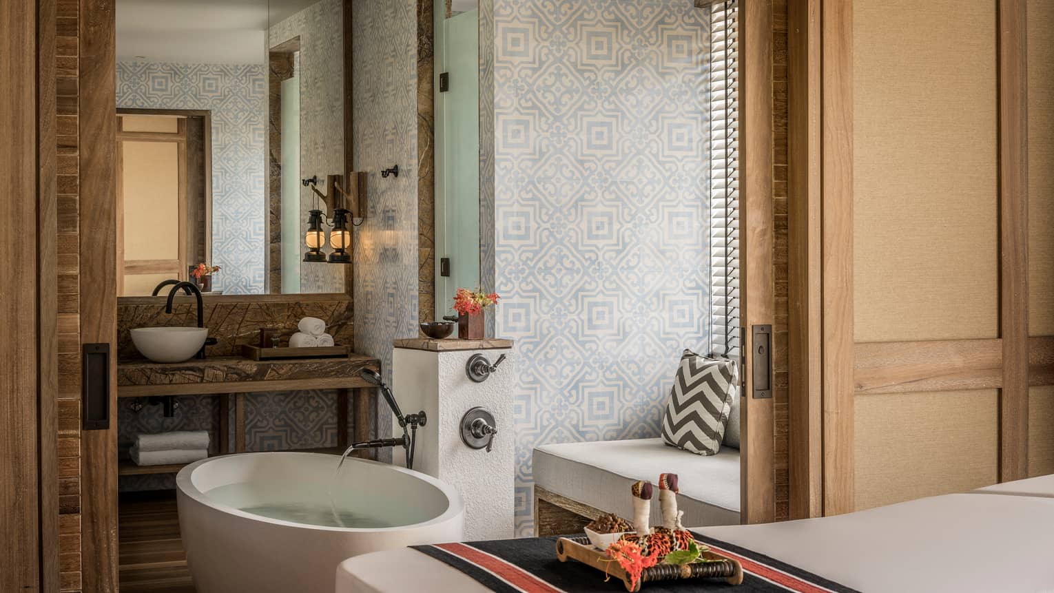 Private spa suite with bath, spa table, sink with vanity and bench seat with pillow