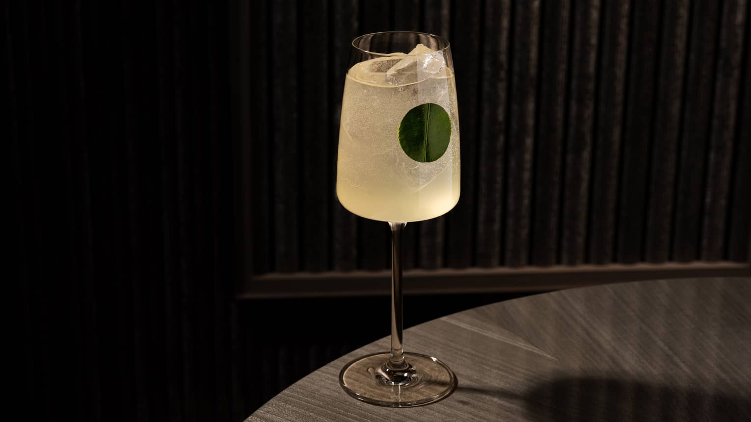 Yellow-hued cocktail served in a tall stemmed glass